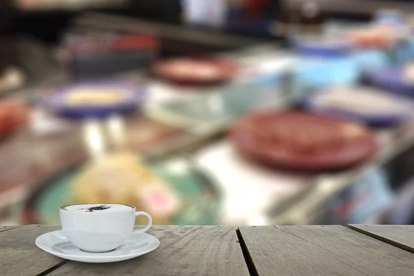 Defocus con terrazza in legno e cappuccino caffè con Sushi su nastro trasportatore in ristorante giapponese per uso di fondo — Foto Stock