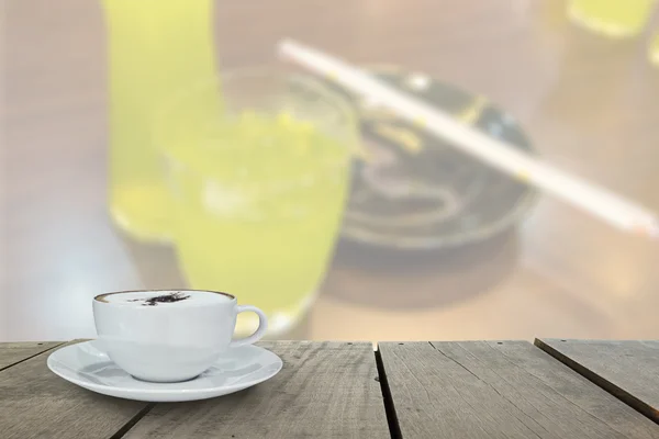 散焦与露台木材和卡布奇诺咖啡，绿茶背景使用的桌子上 — 图库照片
