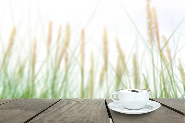 Verse groene gras in de prachtige weide en koffie cup op veranda — Stockfoto