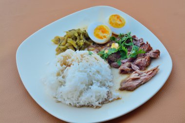 Stewed pork leg on rice on desk.