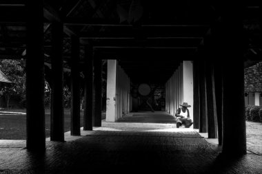 Old man sit under roof alone in home with dramatic style