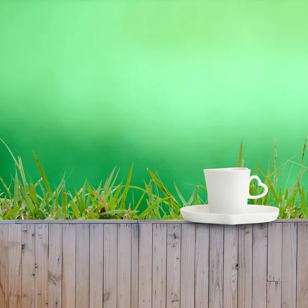 Koffiekopje zetten hek als groene achtergrond textuur — Stockfoto