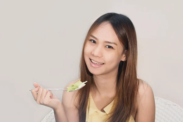 Närbild av vacker Asien kvinna solbränna hud äta sallad på Hom — Stockfoto
