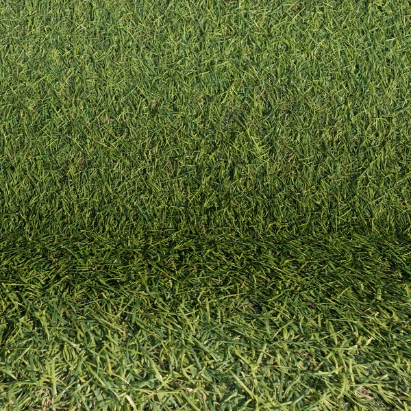 Caldding grama artificial e piso como textura de fundo — Fotografia de Stock