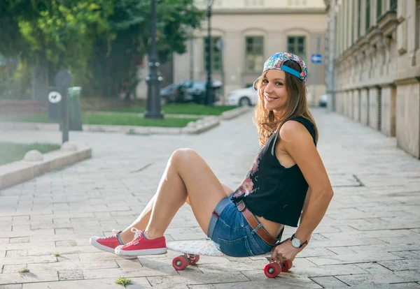 Hipster girl with skateboard posing in city — Stock Photo, Image