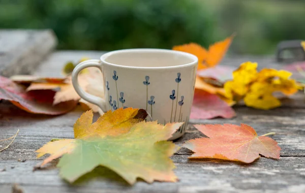 Heißer Kaffee und Herbstblätter auf Holz-Hintergrund - saisonales Relax-Konzept — Stockfoto