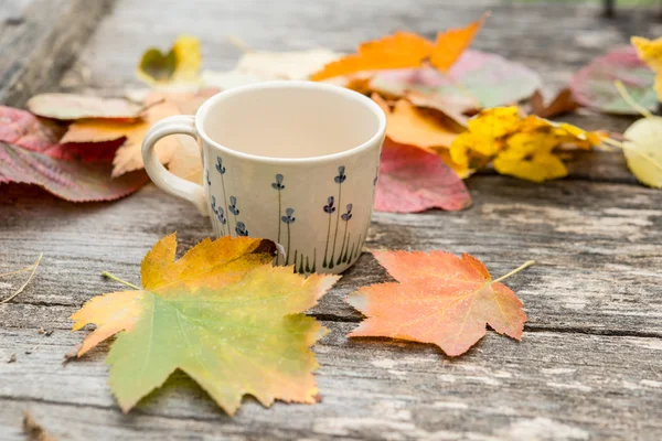 Sıcak kahve ve vintage ahşap arka plan - mevsim sonbahar yaprakları kavramı relax