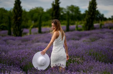 Beyaz şapkalı, lavanta tarlasında güzel bir genç kadın.