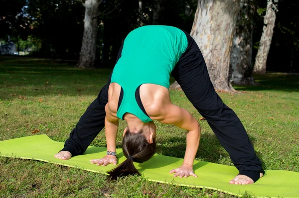 Mujer joven está practicando yoga — Foto de Stock