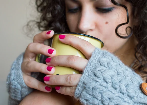 Νεαρή γυναίκα που πίνει καφέ στο σπίτι το χειμώνα — Φωτογραφία Αρχείου