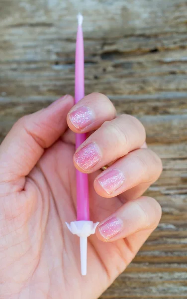 Pink birthday candle in woman's hand — Stock Photo, Image