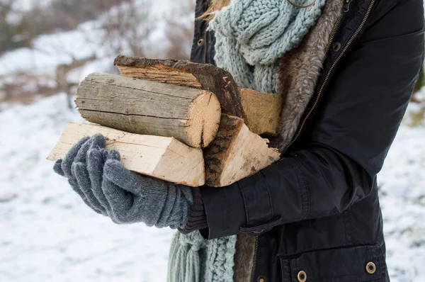 Stylish young woman posing with wooden logs for bonfire — Stock Photo, Image