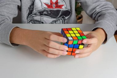 Perma, Rusya, Kasım 02 2020 Rubik küpü bir çocuğun elinde. Çocuk bir Rubik küpünü arka planda tutuyor, onunla oynuyor. Kapat..