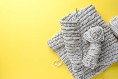 Düz örgü örüyorum. Yatay örgü kolajı, parlak bir arka planda iplik ve örgü iğneleri. Boşluğu kopyala.