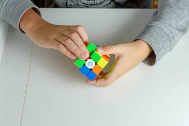 Perma, Rusya, Kasım 02 2020 Rubik küpü bir çocuğun elinde. Çocuk bir Rubik küpünü arka planda tutuyor, onunla oynuyor. Kapat..
