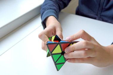 Hafif arka plandaki bir çocuğun elindeki mantıklı bir oyuncak. Çocuk onunla oynarken bulmacayı tutuyor. Kapat..