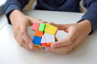 Hafif arka plandaki bir çocuğun elindeki mantıklı bir oyuncak. Çocuk onunla oynarken bulmacayı tutuyor. Kapat..