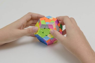 Hafif arka plandaki bir gencin elindeki mantıklı bir oyuncak. Çocuk onunla oynarken bulmacayı tutuyor. Kapat..