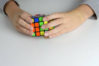 Hafif arka plandaki bir gencin elindeki mantıklı bir oyuncak. Çocuk onunla oynarken bulmacayı tutuyor. Kapat..