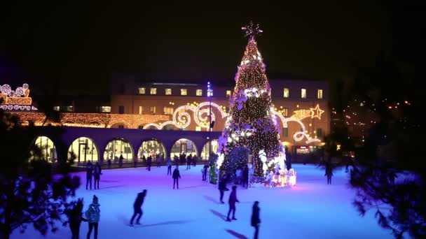 人们在冰场上的圣诞树上溜冰 — 图库视频影像