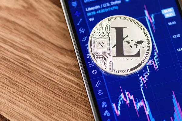 Litecoin / U.S. ile akıllı telefon. Üstüne dolar grafiği ve bozuk para.. 