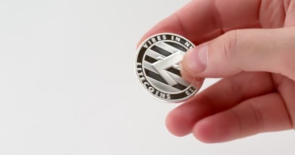 Man Examines Litecoin Coin While Holding His Hand White Background — Stock Video