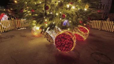 Geceleyin ışıldayan çelenklerle süslenmiş Noel ağacı