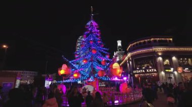 Kiev, Ukrayna - 27 Aralık 2020: İnsanlar geceleri Noel ağacına biniyor. Alt toplar rahat koltuklar olarak tasarlanmıştır..