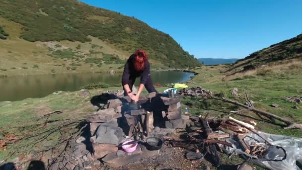 女人在湖边篝火边做饭. — 图库视频影像