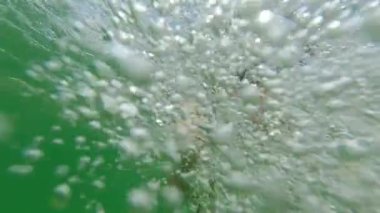 Adam suyun altına dalıyor ve deniz tabanında yüzüyor..