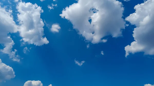 Mavi gökyüzüne karşı beyaz kümülüs bulutları. 