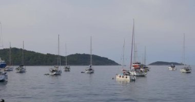 Yatlar bir yaz akşamı marinada bir şamandıraya demirlendi, Hırvatistan.