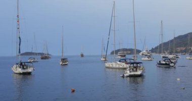 Yatlar bir yaz akşamı marinada bir şamandıraya demirlendi, Hırvatistan.