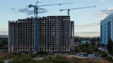 Sonbaharda gökyüzünde vinçleri olan apartman bloğu inşaatı kentsel büyüme ve gelişimi gözler önüne seriyor