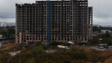 Etkileyici bir hızlandırılmış çekim, şehirde yüksek katlı bir apartman inşaatı projesinin ilerlemesini ortaya çıkarmak için eğik bir hareketi kullanır.