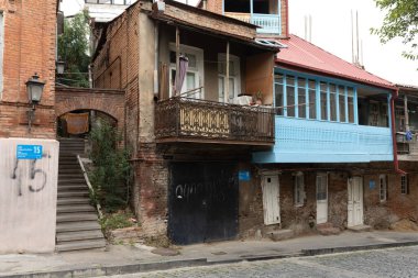 Tiflis, Georgia-- 01 Ekim 2018: Tarihi tuğla, süslü demir bir balkon ve parlak mavi renkli parlak ahşap bir balkon içeren geleneksel bir Tiflis konut manzarası.