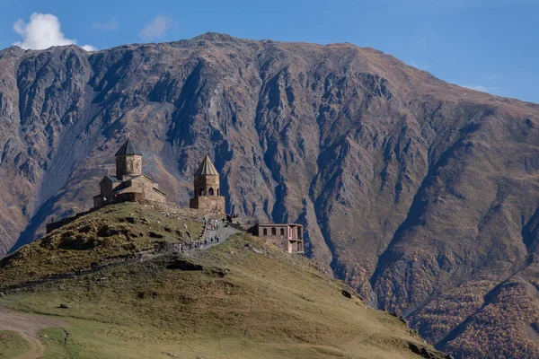 Tarihsel Gergeti Trinity Kilisesi manzarası, Gürcistan 'ın Stepantsminda kentindeki Kafkaslar' ın geniş bir zeminine karşı bir tepenin üzerine tünemişti..