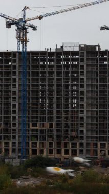 Dinamik dikey video zaman atlaması, kentsel bir çevrede yüksek katmanlı bir inşaat projesinin hızlı ilerlemesini gösteriyor.