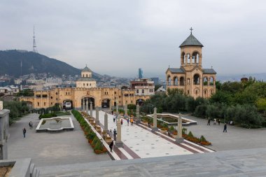 Tiflis, Georgia- 01 Ekim 2018: Tiflis, Gürcistan 'daki Kutsal Üçlü Katedrali' nin (Sameba) manzarası, çan kulesi, kale benzeri duvar ve bulutlu bir günde geniş bir yaya geçidi de dahil olmak üzere.