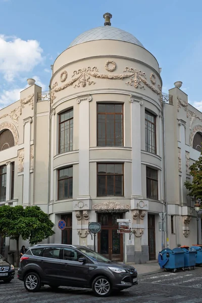 Tiflis, Georgia- 01 Ekim 2018: Tiflis, Gürcistan 'daki süslü, tarihi bir köşe binasının dikey görünümü, güneşli bir günde yuvarlak bir kubbe, dekoratif sıva işi ve büyük pencereler.