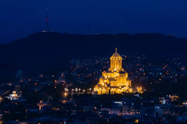 Gürcistan 'ın Tiflis kentindeki görkemli Kutsal Üçlü Sameba Katedrali' nin göz kamaştırıcı manzarası alacakaranlıktaki karanlık şehrin üzerinde sıcak altın ışıkla parlıyordu..