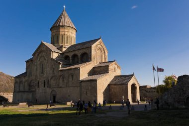 Mtskheta, Georgia- 3 Ekim 2018: Mtskheta, Gürcistan 'daki tarihi Svetitskhoveli Katedrali taş kale duvarları içinde yer almaktadır. Turistler güneşli bir günde antik Ortodoks kilisesini ziyaret ediyorlar.
