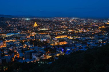 Gürcistan 'ın aydınlık başkenti Tiflis' in panoramik gece manzarası, Sameba Katedrali şehrin hakimi..