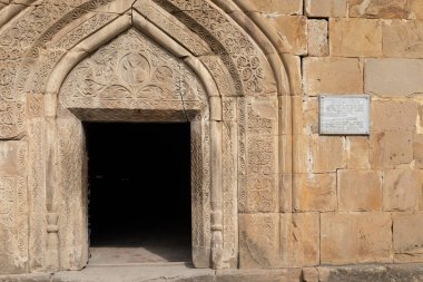 Güneşli bir günde Gürcistan 'daki Ananuri Kalesi kompleksi içindeki Hüküm Kilisesi' nin karmaşık bir şekilde oyulmuş taş kapısının yatay görüntüsü..