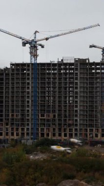 Dinamik dikey video zaman atlaması, kentsel bir çevrede yüksek katmanlı bir inşaat projesinin hızlı ilerlemesini gösteriyor.