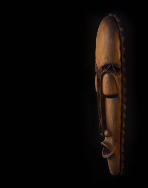 Siyah arka planda tahta Afrika maskesi.