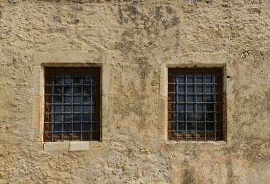 Arkaplan olarak duvardaki eski parmaklıklı pencere