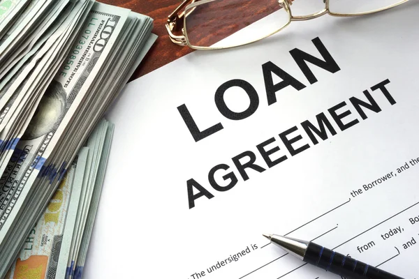 Loan agreement on a table and dollars. — Stock Photo, Image