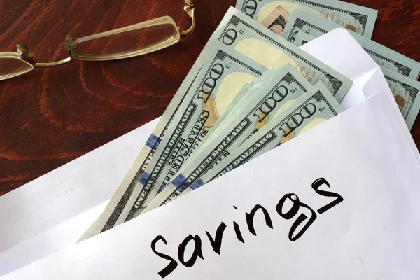 Savings written on an envelope with dollars. — Stock Photo, Image