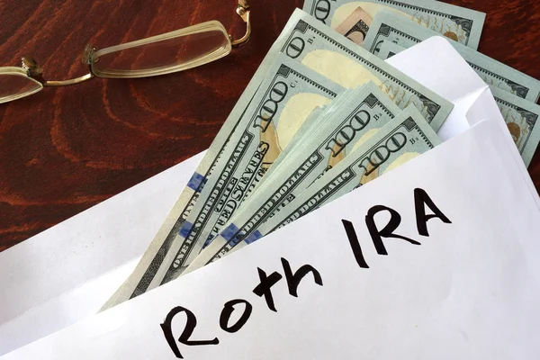 Roth IRA written on an envelope with dollars. — Stock Photo, Image